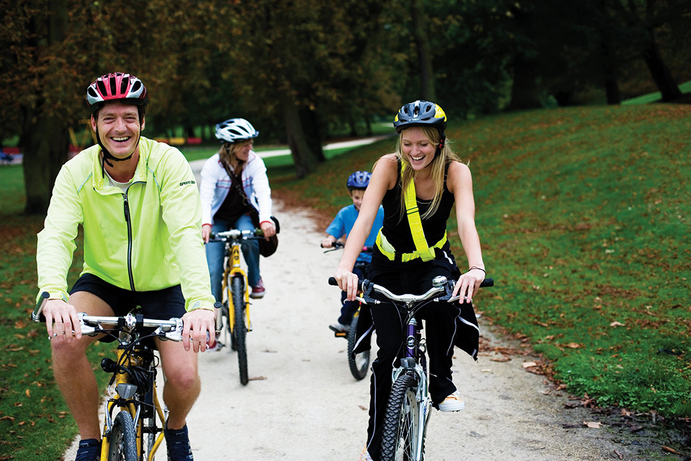 A family cycling through a park