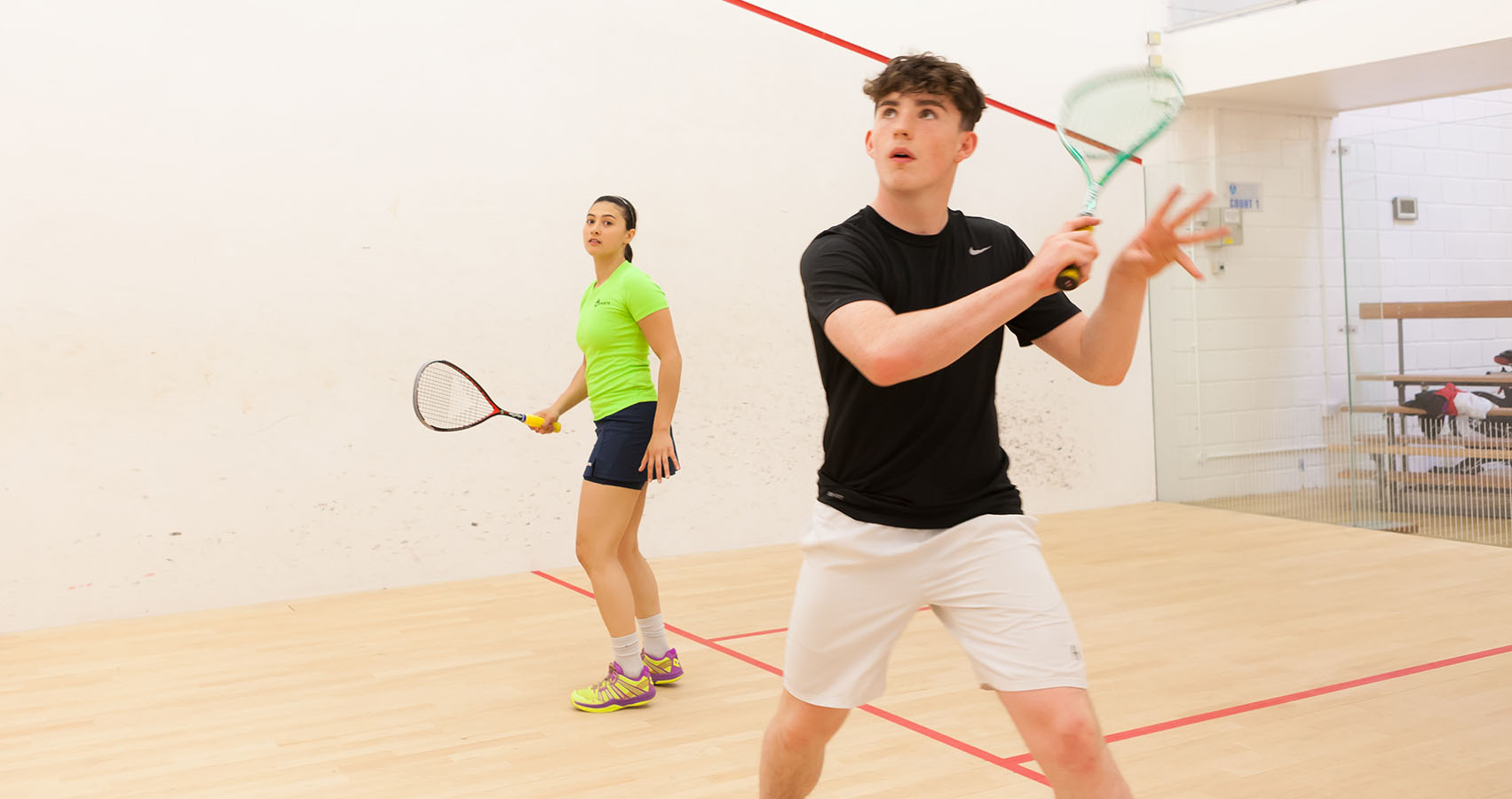 Two people playing squash 